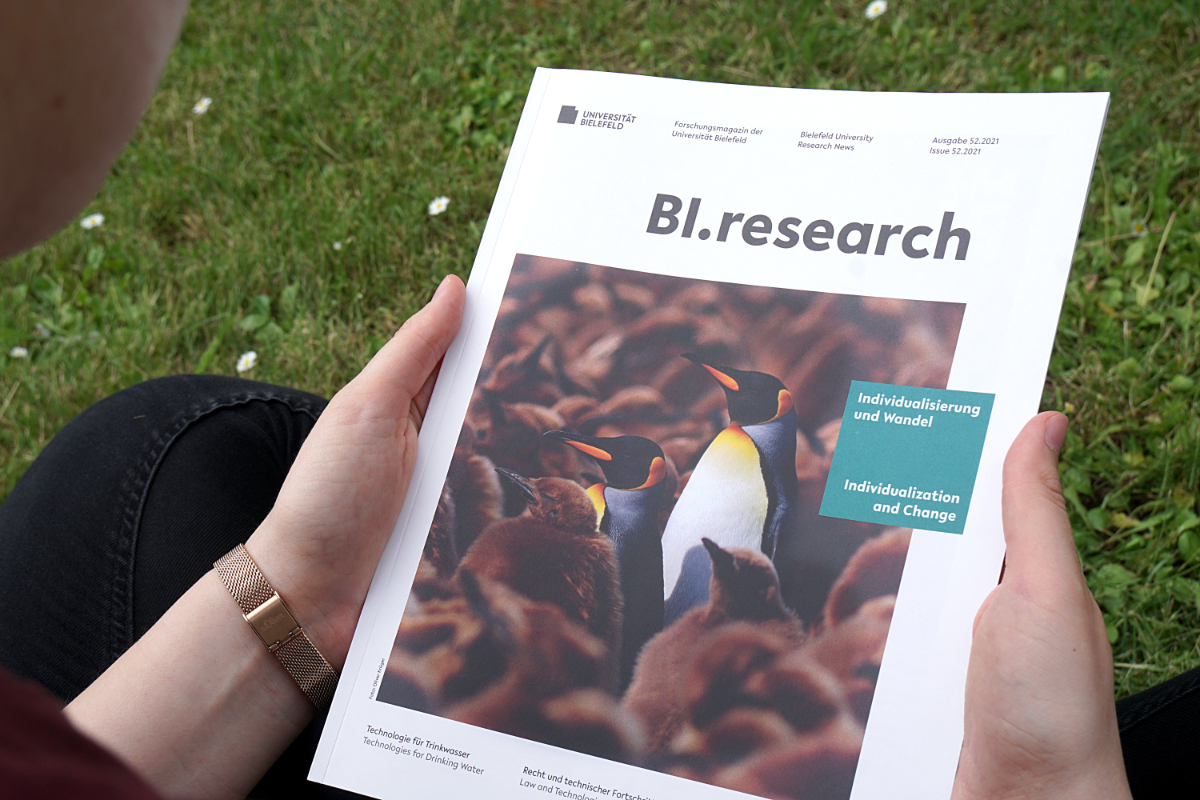 Photo of a person holding an issue of the research magazine BI.research.