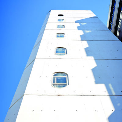 Turm des Hauptgebäudes der Universität Bielefeld vor blauem Himmel