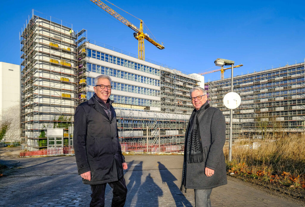 Das Baugerüst wird bereits entfernt: Uni-Kanzler Dr. Stephan Becker und BLB NRW-Niederlassungsleiter Wolfgang Feldmann freuen sich über die neue Fassade am Universitätshauptgebäude.