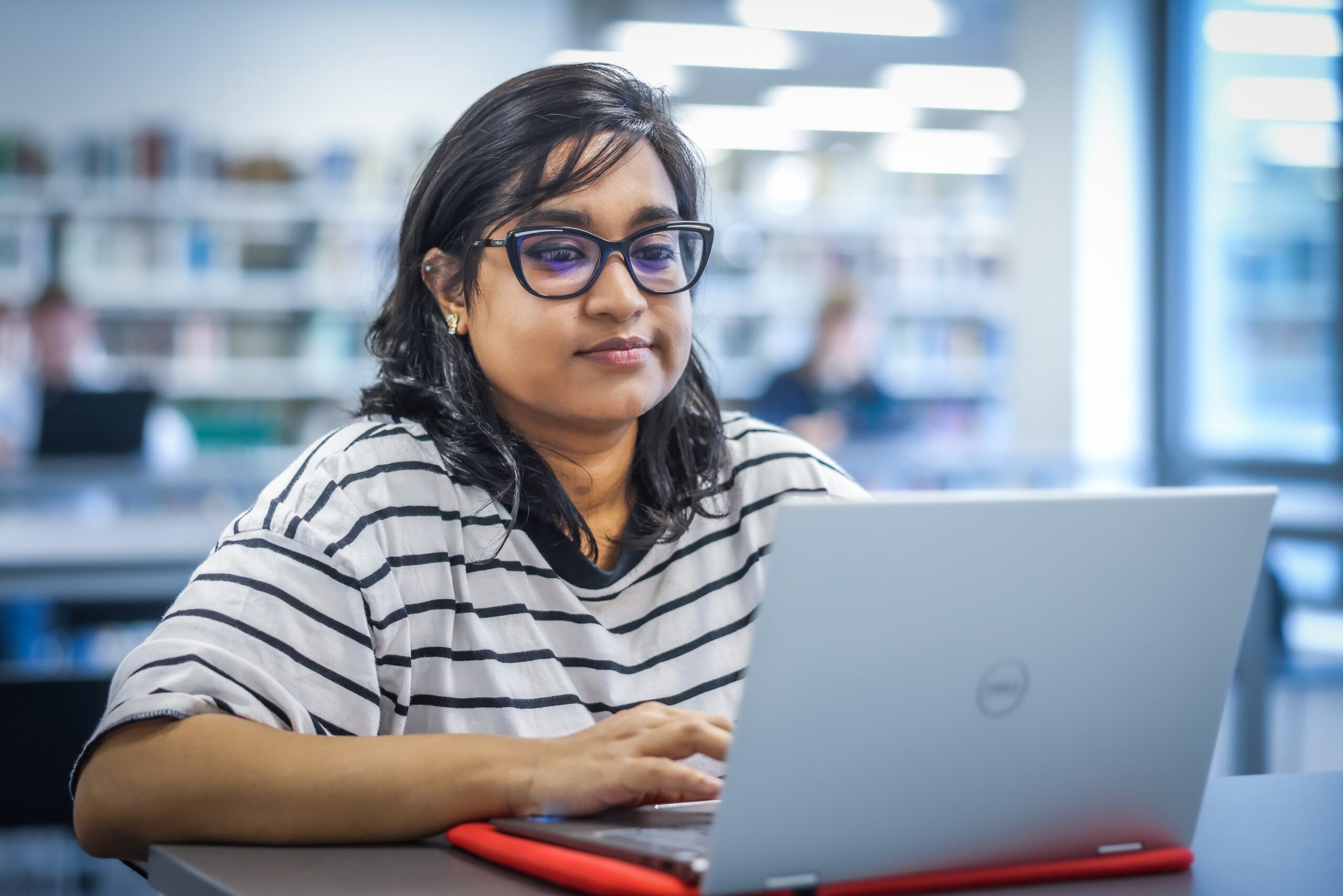 Pallabi Chattopadhyay sits at her laptop in the library.