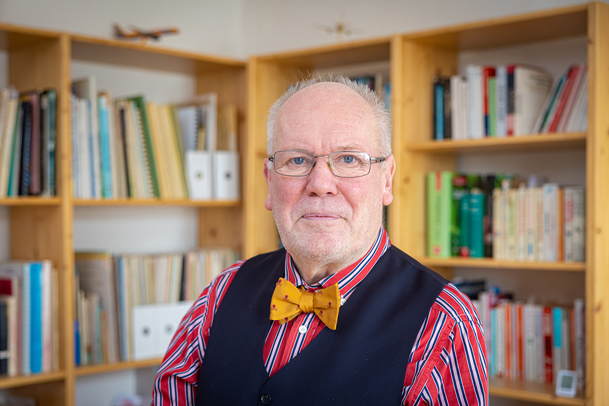 Picture of the Person: Professor Dr Peter Bernhard Ladkin in front of a shelf with books.