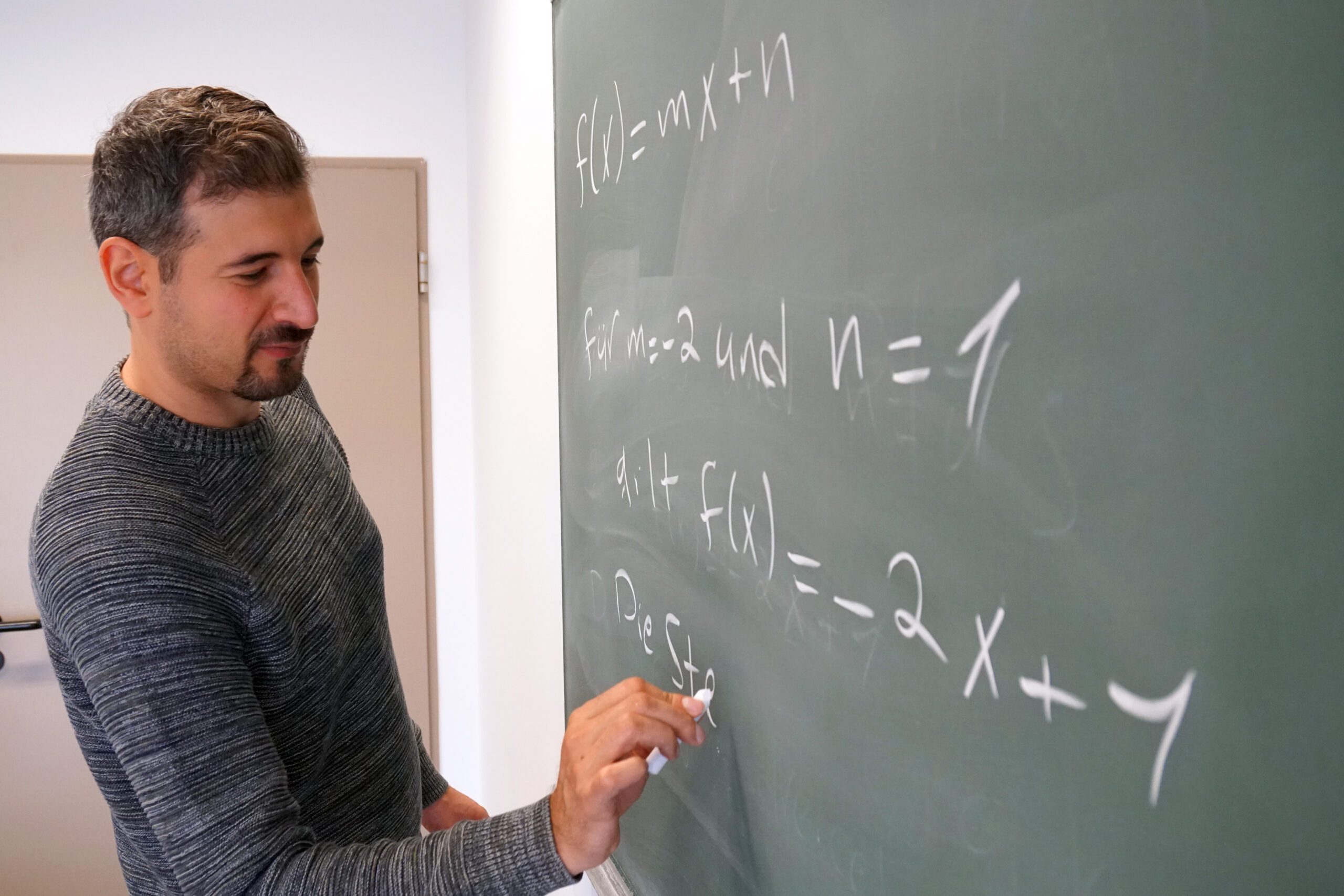 Mustafa Braun schreibt mathematische Formal an die Tafel.