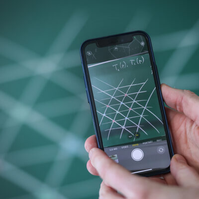 Blick durchs Smartphone auf ein mathematisches Tafelbild