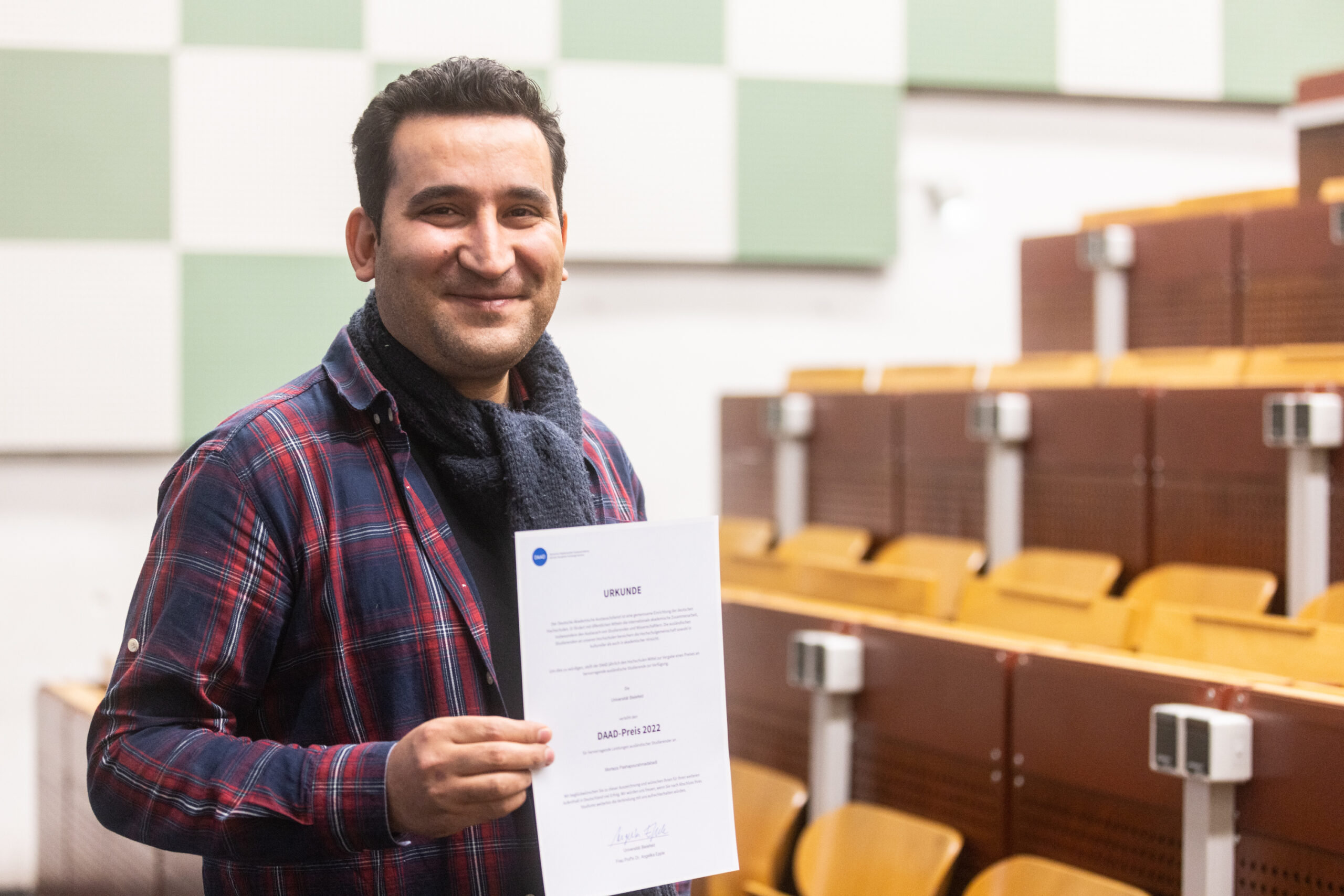 Morteza Pashapourahmadabadi aus der Fakultät für Physik mit seiner Urkunde des DAAD-Preises 2022.