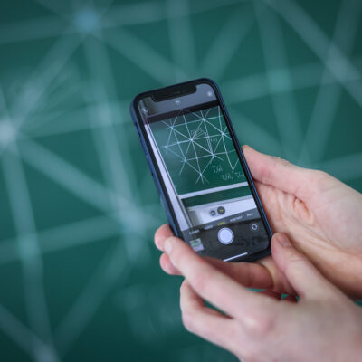View through the smartphone on a mathematical blackboard screen
