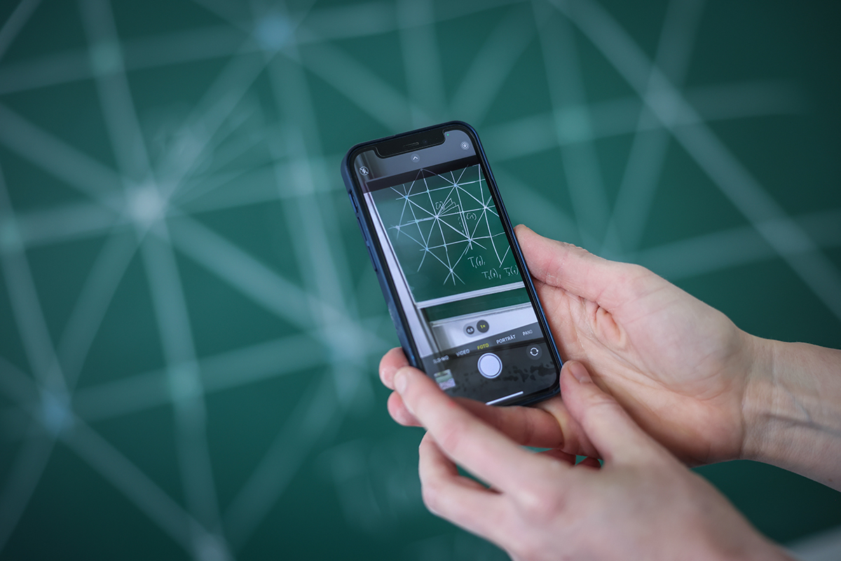 Blick durchs Smartphone auf ein mathematisches Tafelbild
