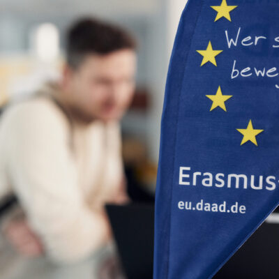 Erasmus+ flag in the foreground and a person in the background.