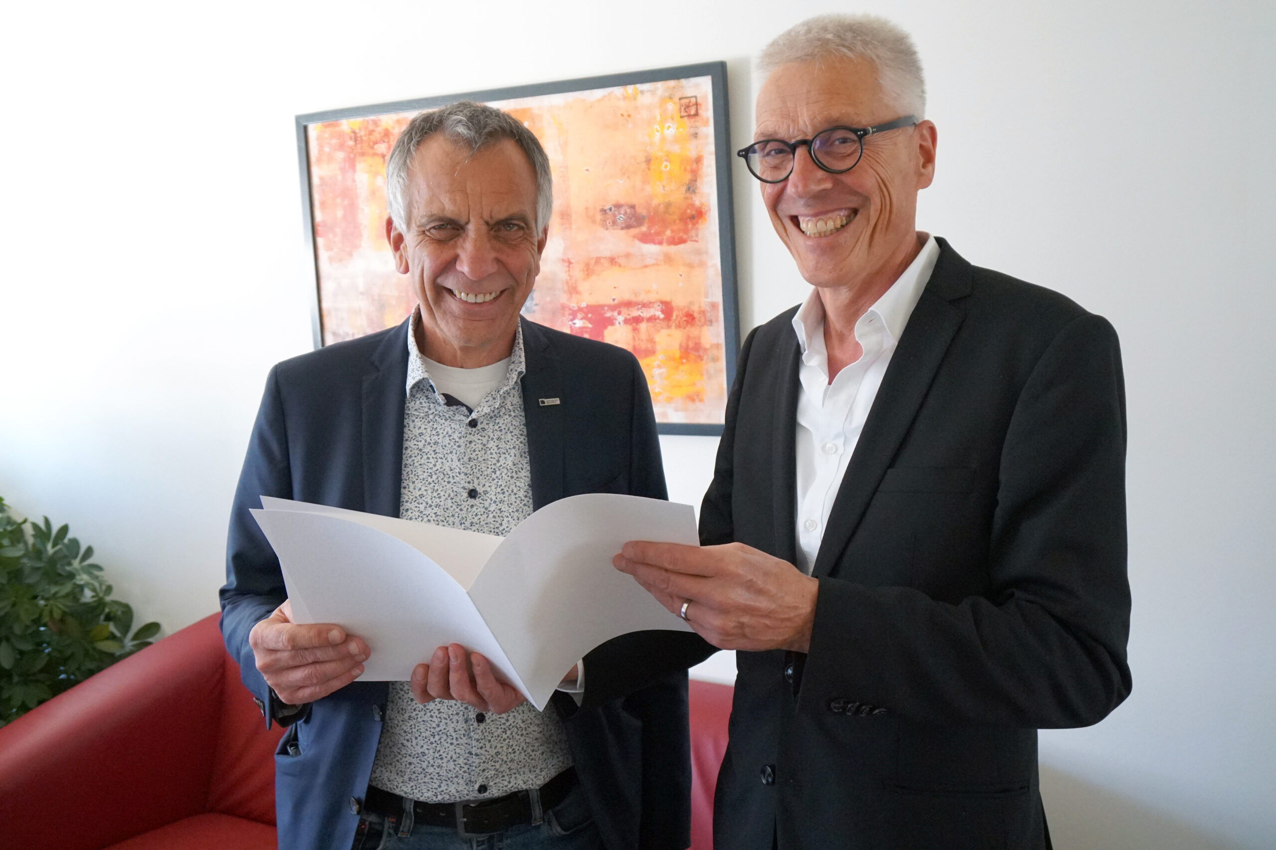 Kanzler Dr. Stephan Becker überreicht Rektor Prof. Dr.-Ing. Gerhard Sagerer seine Ruhestandsurkunde.