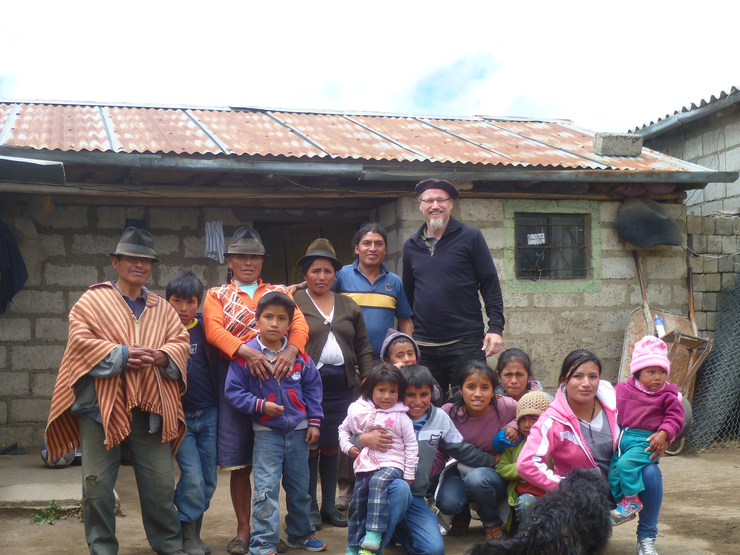 Prof. Olaf Kaltmeier umringt von Mitgliedern seiner Patenfamilie in Ecuador vor einer Hütte.