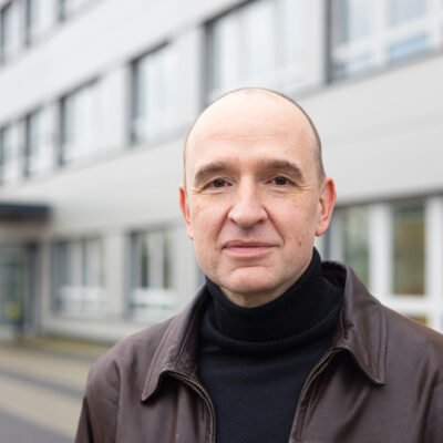 Professor Bauer vor einem Gebäude der Universität Bielefeld.