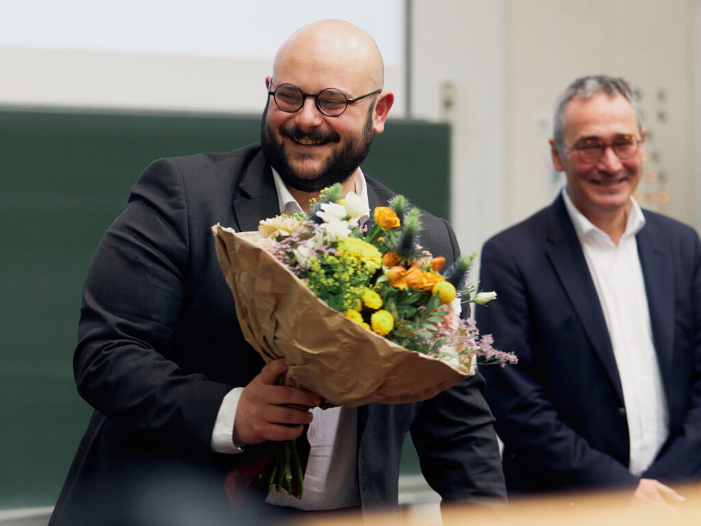 Promotionsstudent Daniele Toro mit Blumenstauß