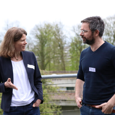 JICE researchers Prof'in Dr Claudia Voelcker-Rehage and Dr Niels Boissonnet are chatting outside.