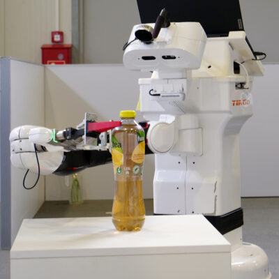 Weißer einarmiger Roboter greift nach einer Kunststoff-Trinkflasche
