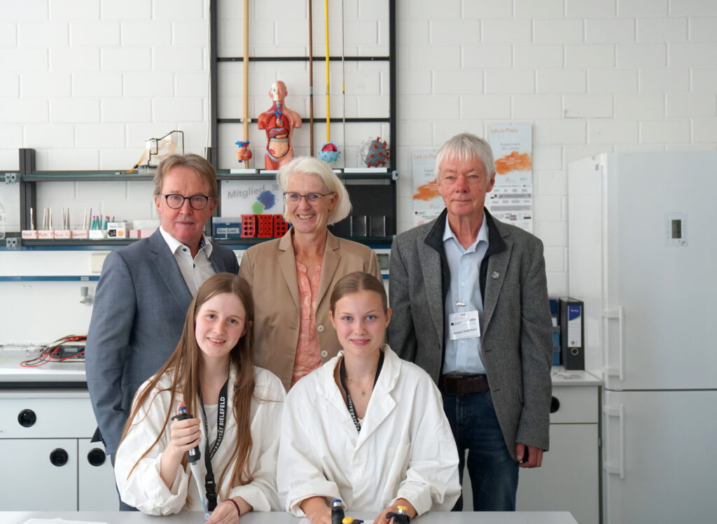 Prof. Dr. Jörn Kalinowski (CeBiTec), Claudia Holle (Osthushenrich-Stiftung) und Prof. Dr. Norbert Grotjohann (teutolab-biotechnologie) (hintere Reihe von links) mit Schülerinnen Rubina Rothenstein und Nieke Charlotte Sütfeld (vordere Reihe von links) im Labor.