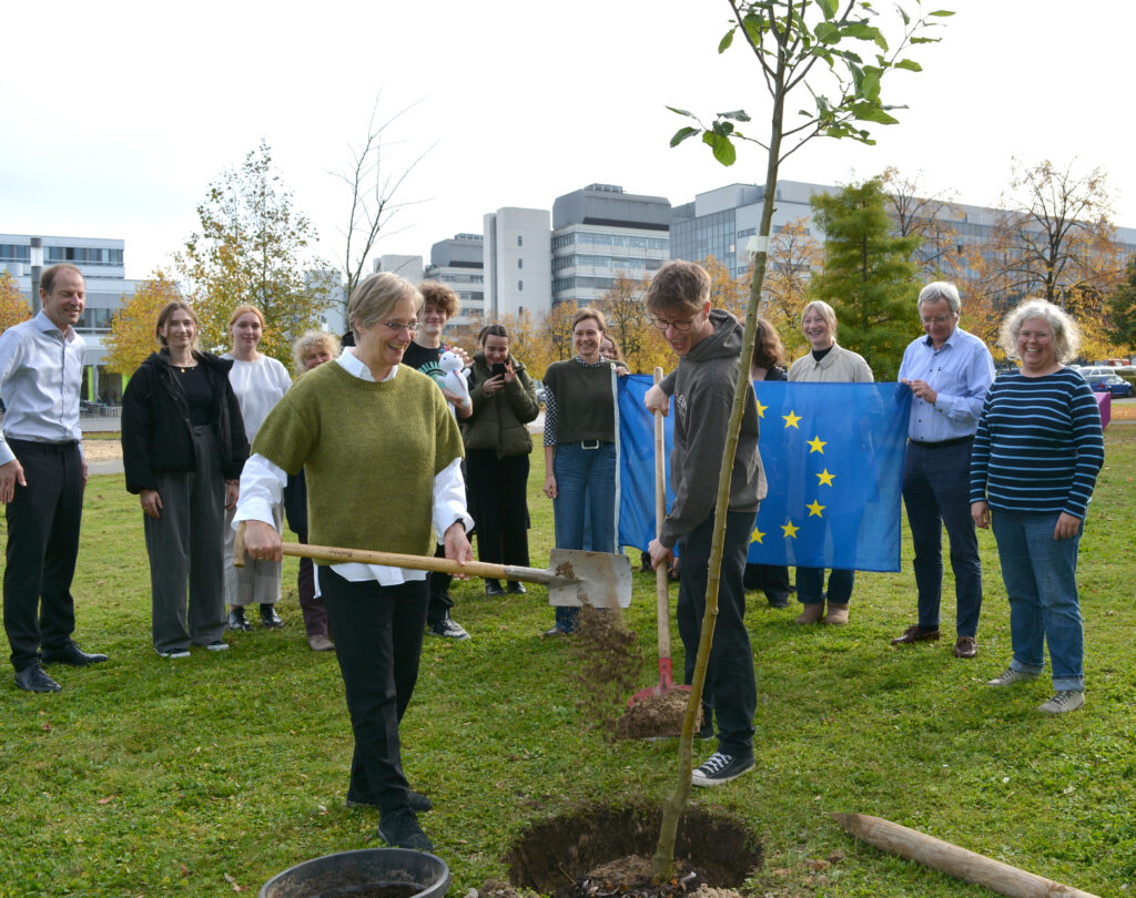 Rektorin Angelika Epple und Peter Margowski, Präsident des Erasmus Student Network (ESN), erweitern das Eurowäldchen um einen Apfelbaum.