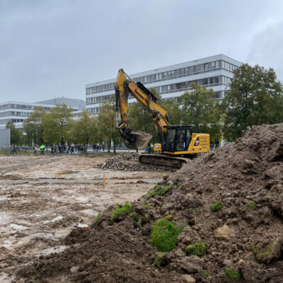 Bagger auf der Wiese vor der Uni