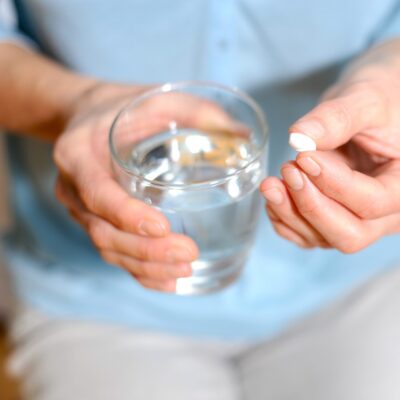 Woman holding a tablet and a glass of water