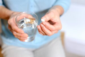 Woman holding a tablet and a glass of water