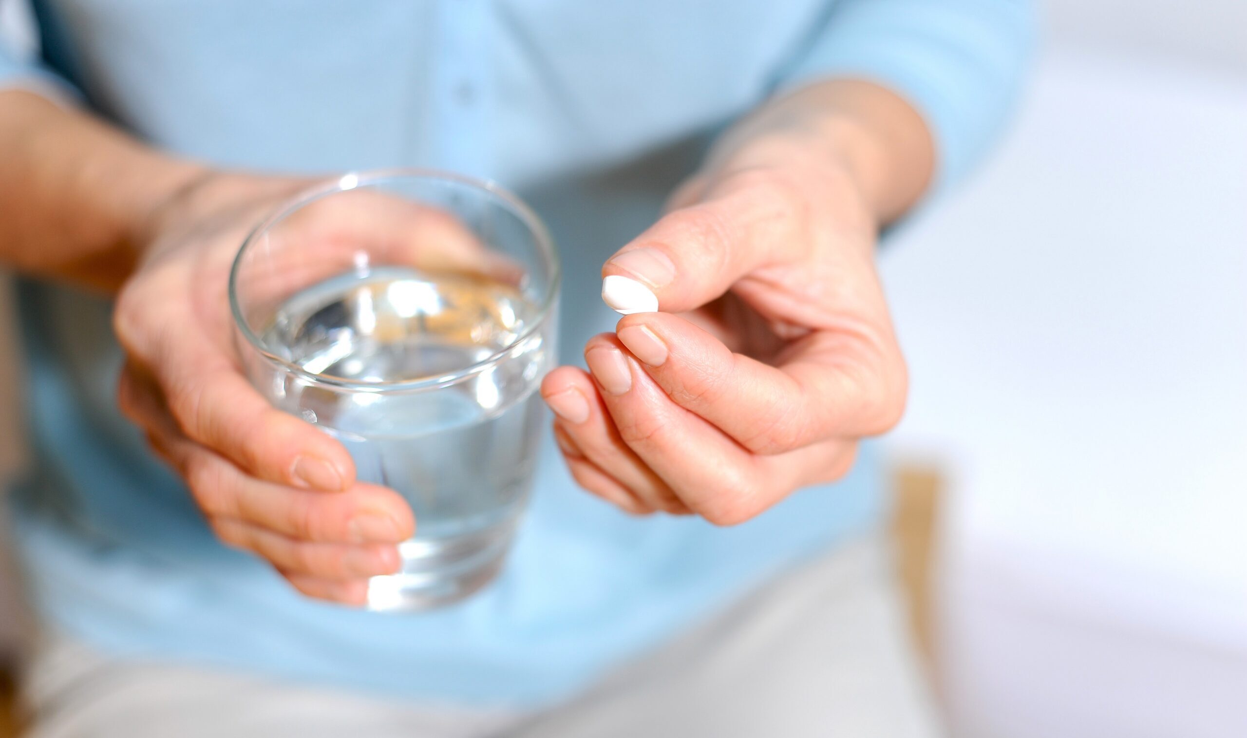 Woman holding a tablet and a glass of water