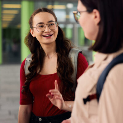 Zwei Studentinnen unterhalten sich auf dem Campus.