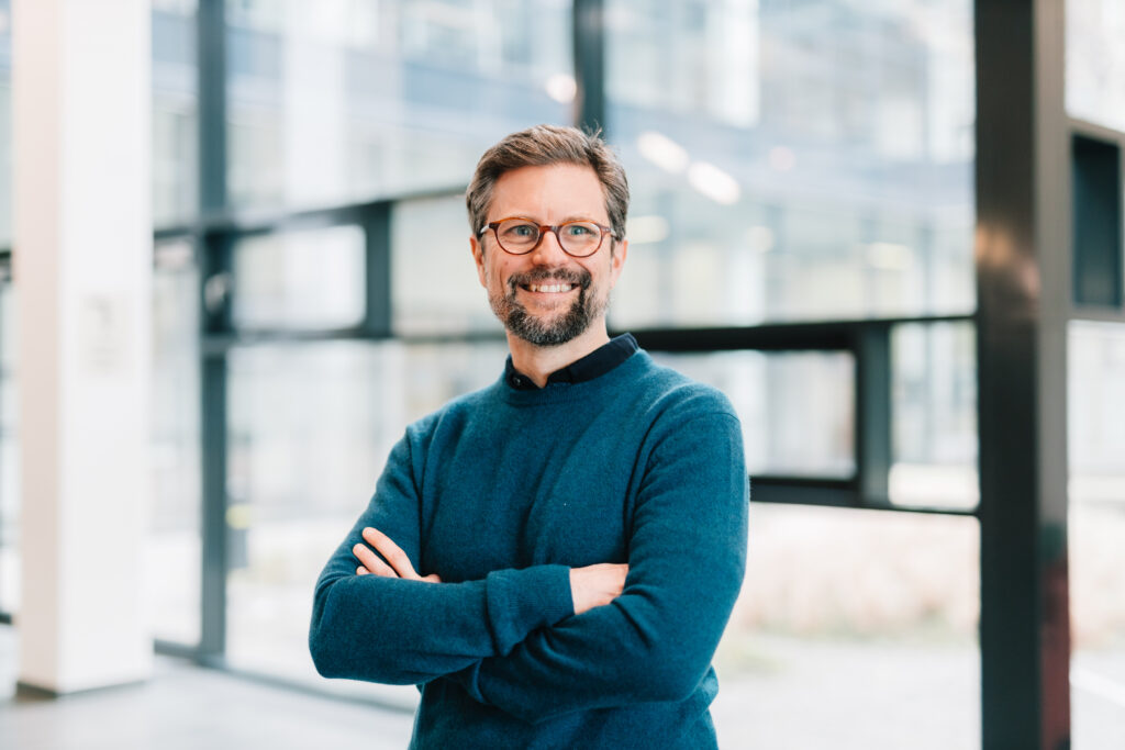 Bild der Person vor einer Fensterfront