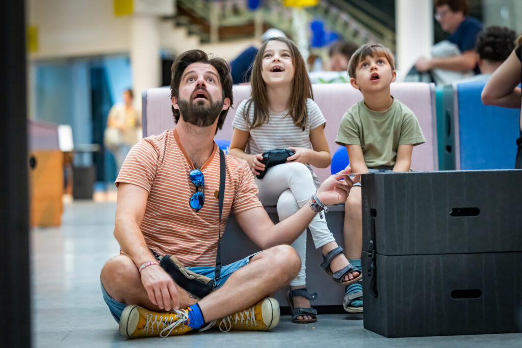Ein Mann und zwei Kinder schauen staunend nach oben