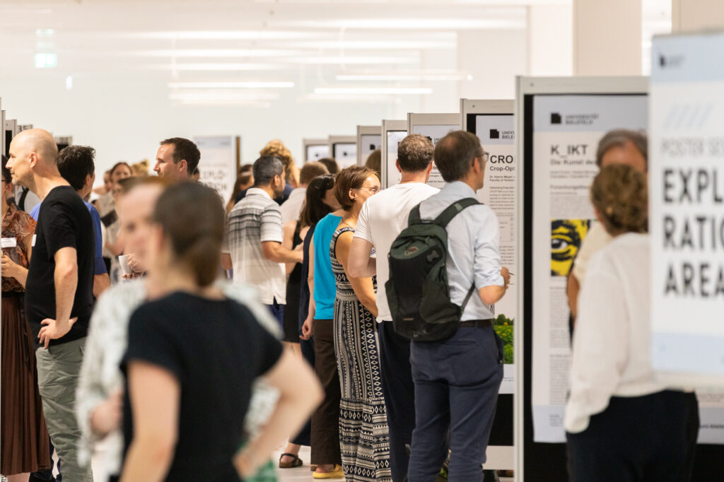 Viele Leute stehen vor verschiedenen Schildern in einer Messe