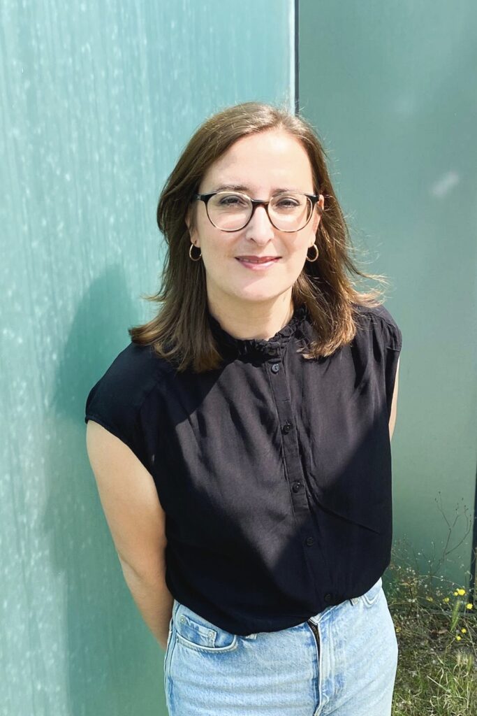 Frau vor einer türkisen Wand.