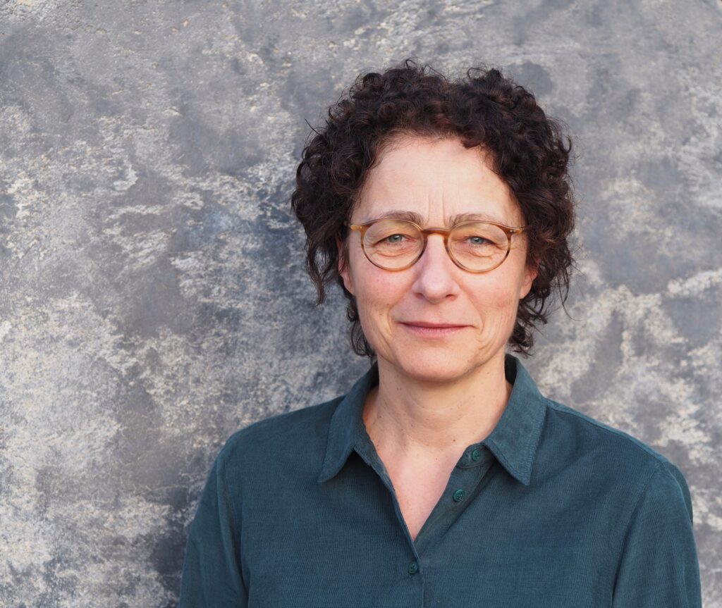 Professorin Dr. Tomke König vor einem marmorierten Hintergrund