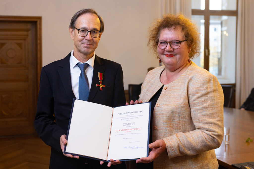 Prof. Dr. Andreas Zick erhält das Verdienstkreuz am Bande des Verdienstordens der Bundesrepublik Deutschland von Christina Osei, Vertreterin des Oberbürgermeisters.