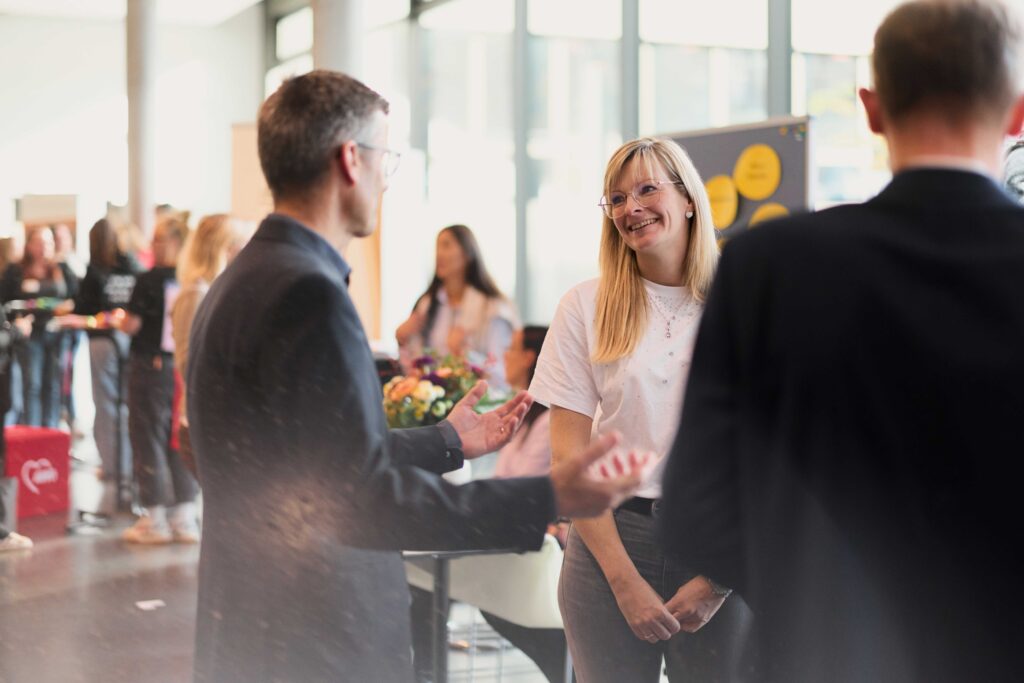 Prof. Dr. Dario Anselmetti (links) und Professor Dr. Ulrich Schäfermeier im Gespräch mit einer Frau bei der perspektive-Messe 2025.