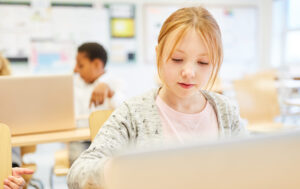 Mädchen arbeitet konzentriert am Laptop