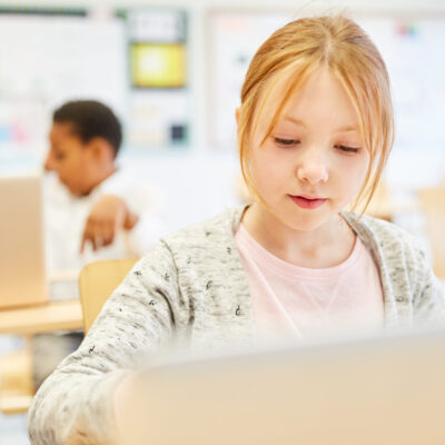 Mädchen arbeitet konzentriert am Laptop