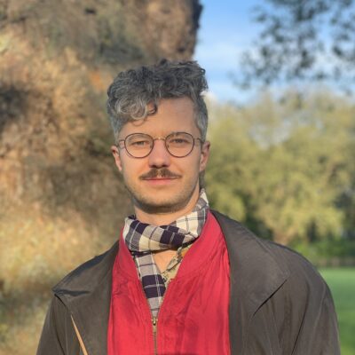 Mann mit Brille vor einem Baum