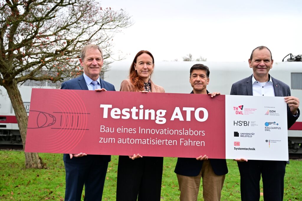 Gruppe hält ein Banner mit der Aufschrift Testing ATO