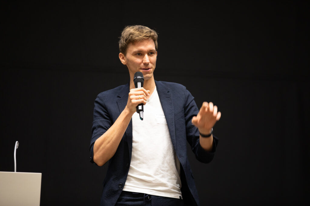 Sören Schlichting hält einen Vortrag, schwarzer Hintergrund