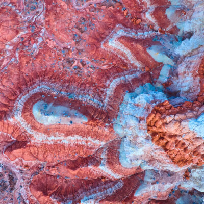 Luftbild der Painted Desert mit wirbelnden roten Felsmustern und erodierten Buttes Luftbild, Luftbildaufnahme, Wüste, rot, Felsen, Muster, Pilz-Hoodoos, Kanab, Utah, Schicht, abstrakt, Natur, Südwesten, Sand, Schichten, Abenteuer, Mineral, Arizona, Textur, blau, isoliert, Umwelt, Formation, Landschaft, unberührt, Erosion, weiß, Reisen, Weite, Vereinigte Staaten, Wildnis, abgelegen, Sonnenlicht, Naturgeschichte, Tag, orange, Wissenschaft, Sediment, goldene Stunde, von oben, Geologie Luftaufnahme der farbenfrohen Painted Desert und der einzigartigen Toadstool Hoodoos in der Nähe von Kanab, Utah, mit lebhaften Gesteinsschichten und abstrakten Mustern, die von der Natur im Südwesten der USA geformt wurden.