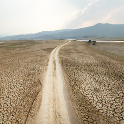 Ausgetrockenete Landschaft mit einem See und Bergen im Hintergrund