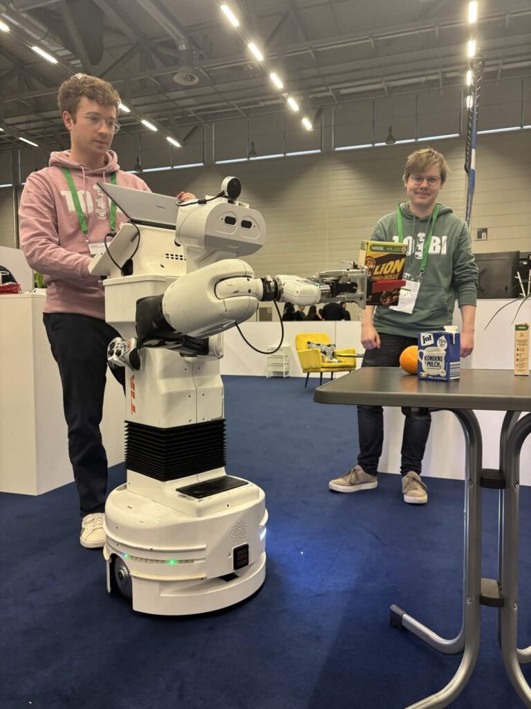 Ein Roboter mit zwei Studierenden
