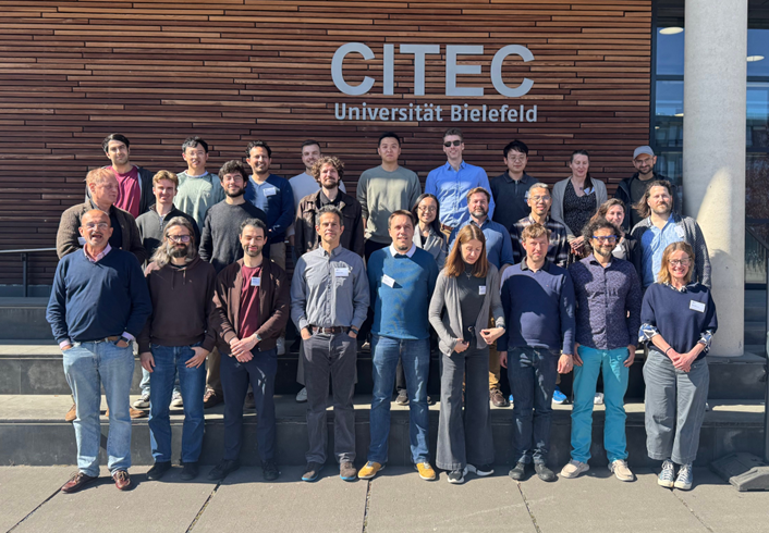 Gruppe von Menschen bei Sonnenschein vor dem CITEC-Gebäude der Universität Bielefeld