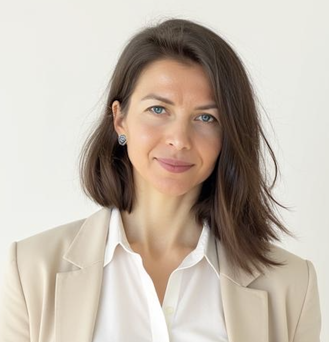 Porträt einer Frau mit schulterlangem braunem Haar in hellem Blazer und weißer Bluse vor neutralem Hintergrund.