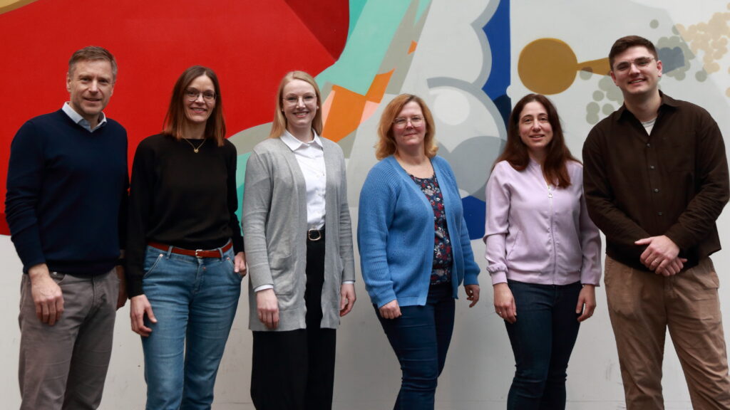 Eine Gruppe von Menschen vor einer bunten Wand